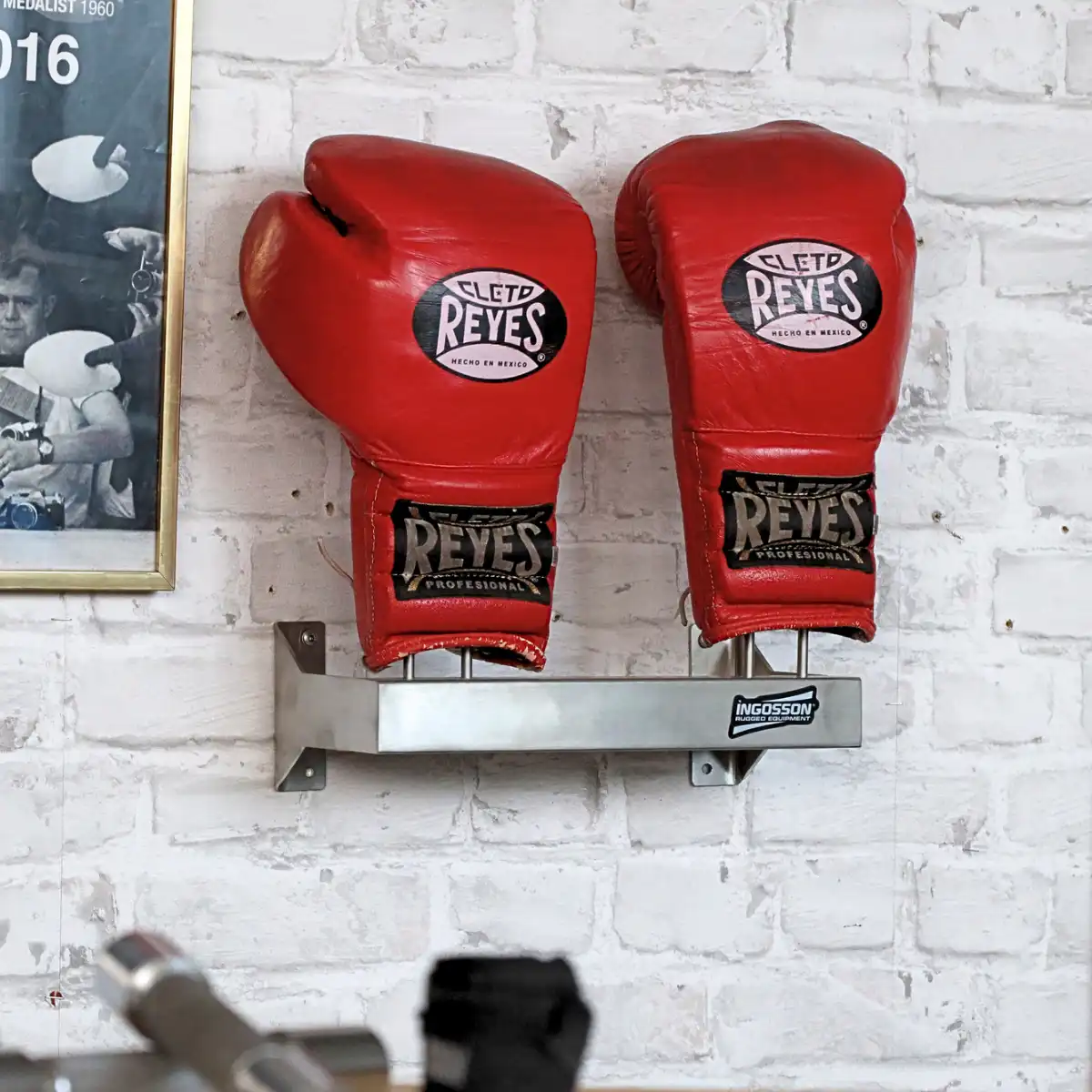 red CletoReyes Boxing gloves on a stainless Ingosson wallrack bolted to a brick wall