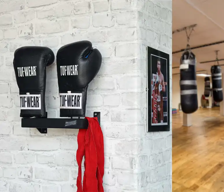 a black boxing glove rack mounted to a brick wall